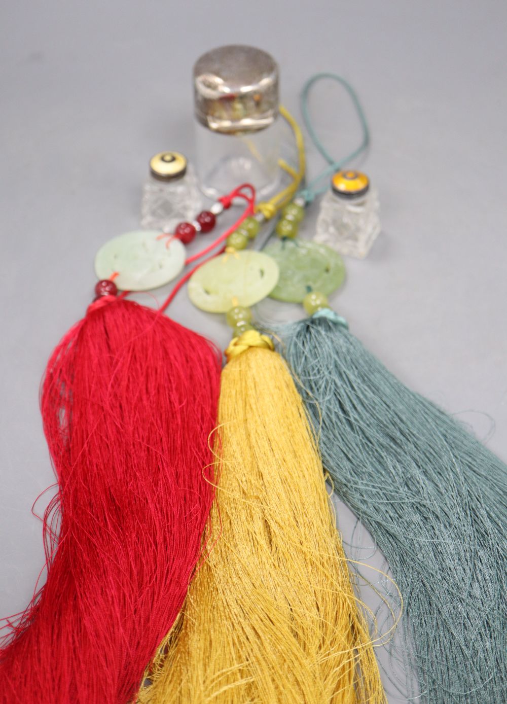 A cut glass and enamelled salt and pepper, a silver lidded scent bottle and three hardstone pendants